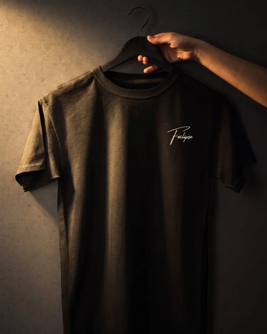Camiseta Signature negra colgada en un gancho, con la firma Feclipse al pecho